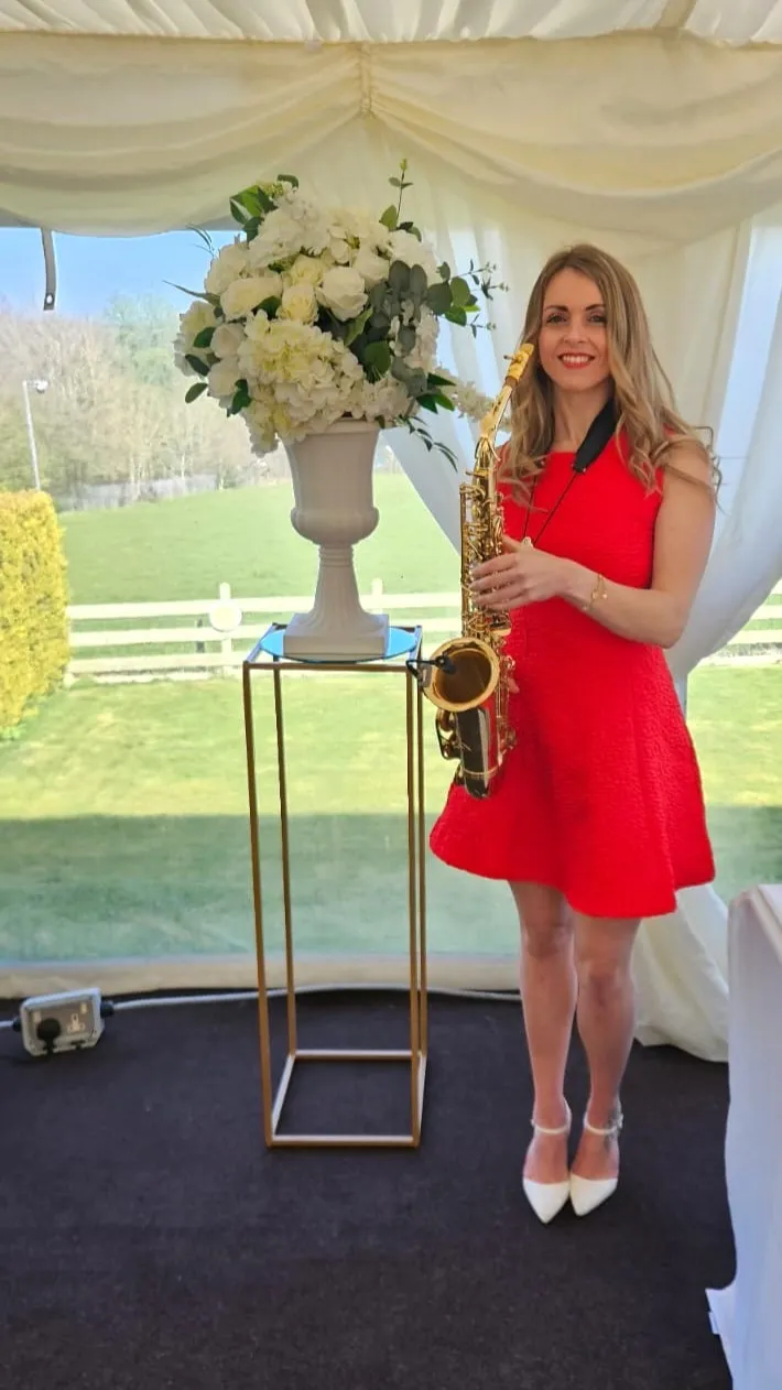 Professional wedding saxophone player holding her saxophone